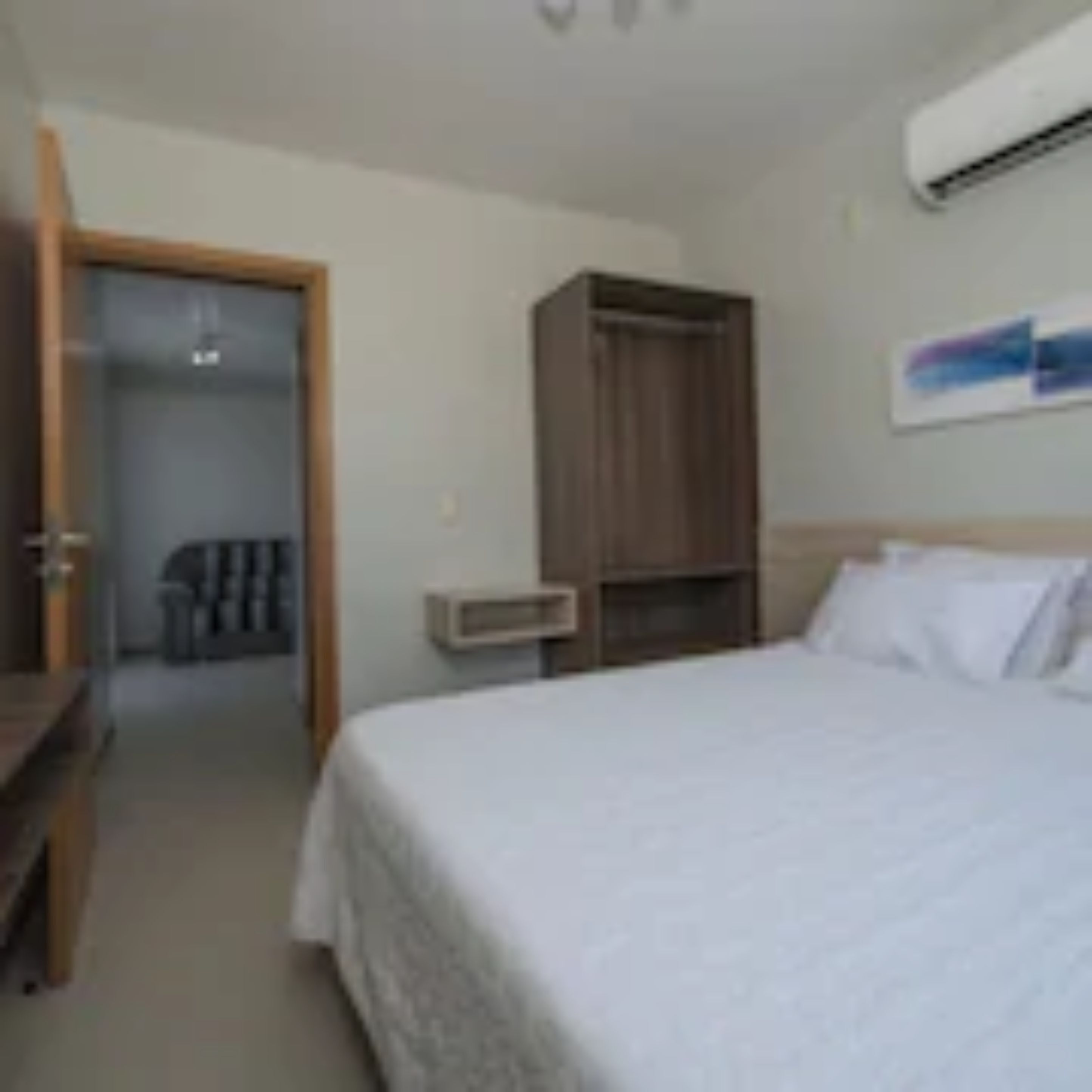 Un dormitorio con cama, armario y escritorio.