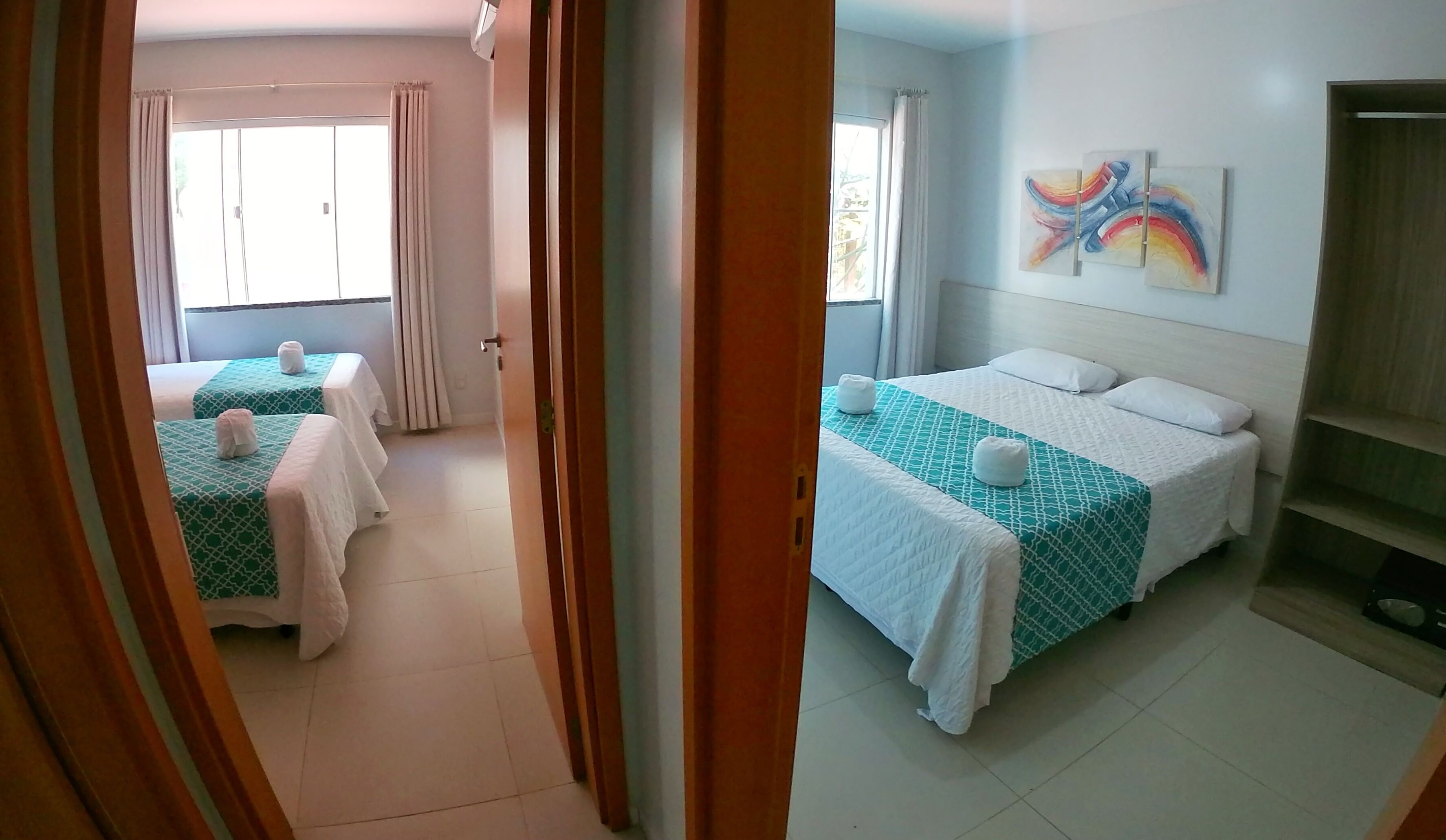 A hotel room with a bed, a bedside table, and a window with curtains.