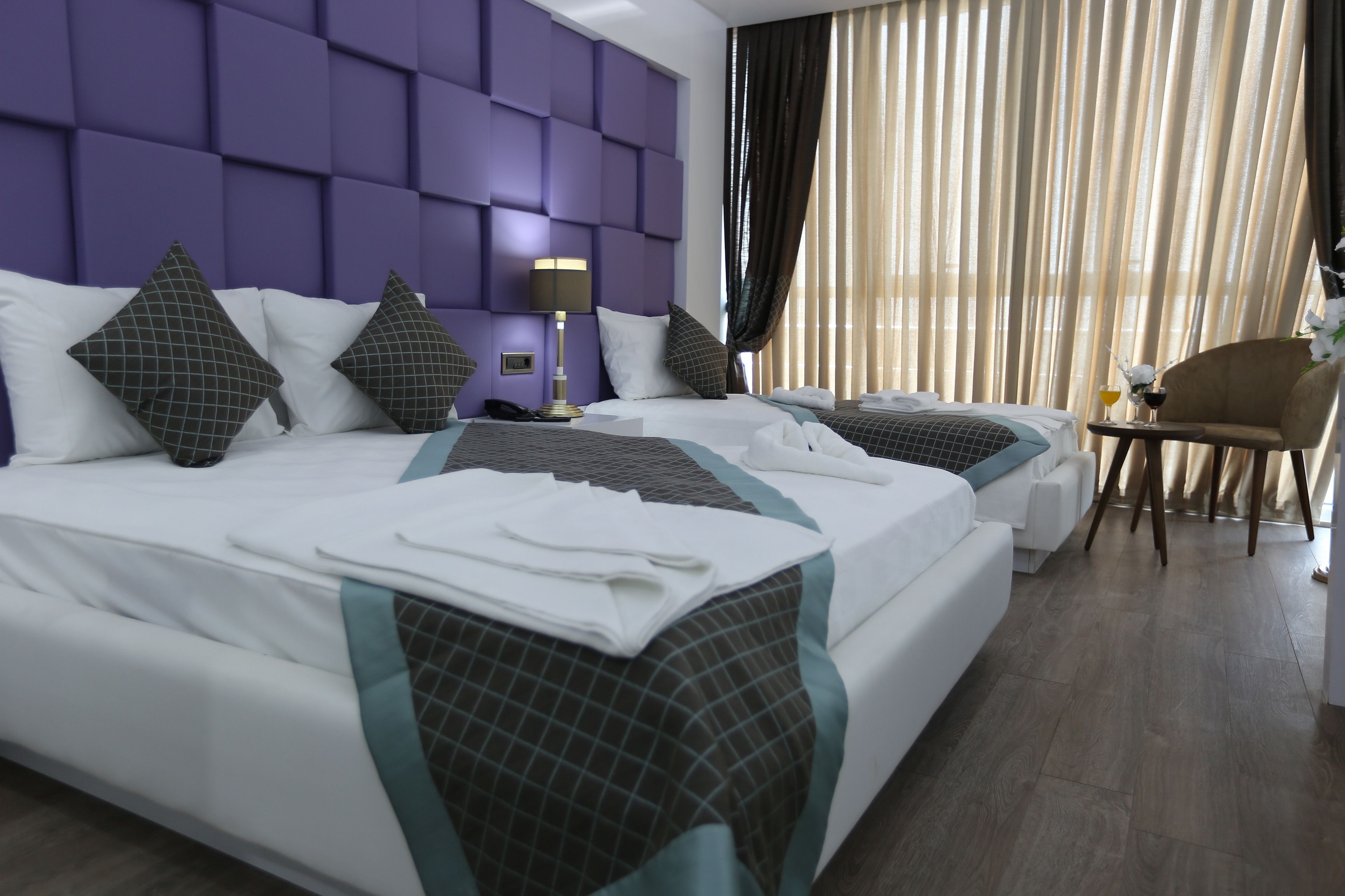 A hotel room with two beds, a desk, and a chair.