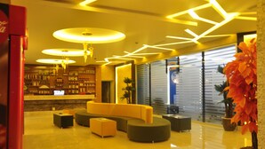 A modern lobby with a curved sofa, round tables, and a large potted plant. - Elips Royal Hotel & Spa (Antalya)