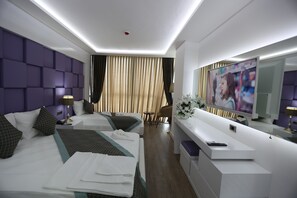 A modern hotel room with two beds, a TV, a desk, and a mirror. - Elips Royal Hotel & Spa (Antalya)