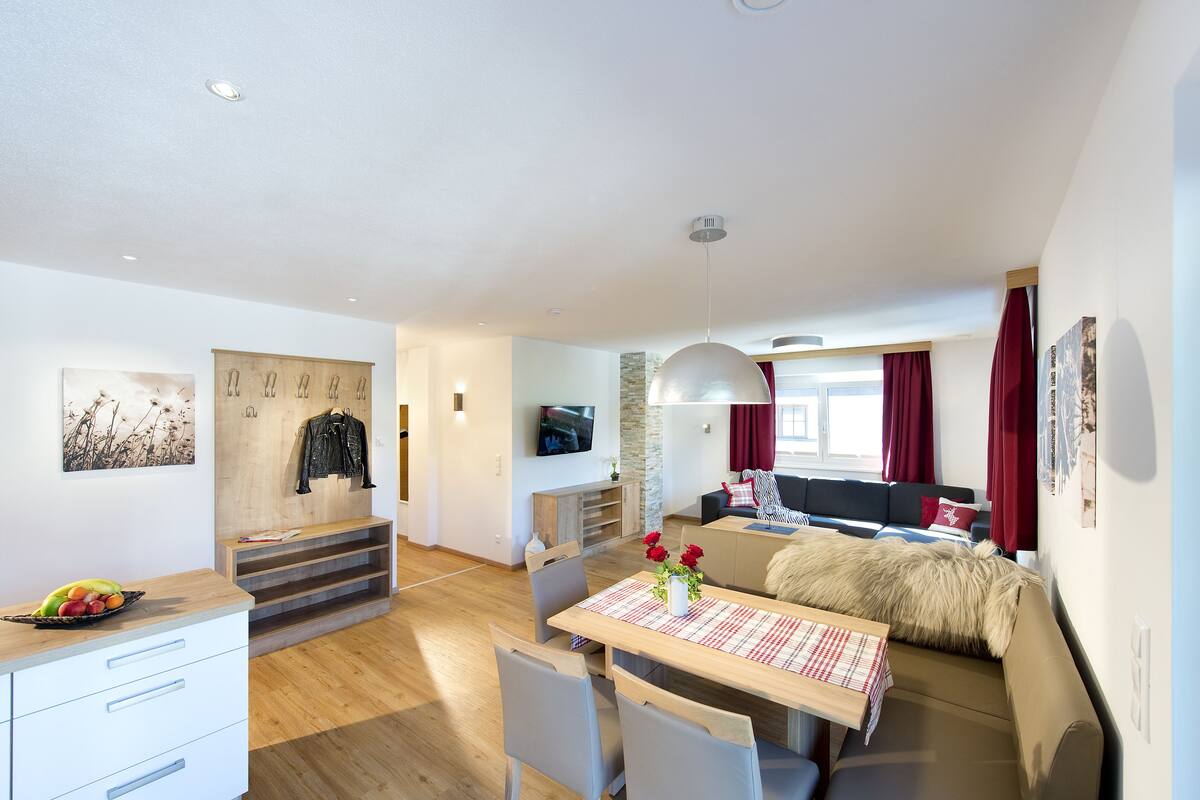 A modern apartment with a dining area, a living room, and a bedroom.