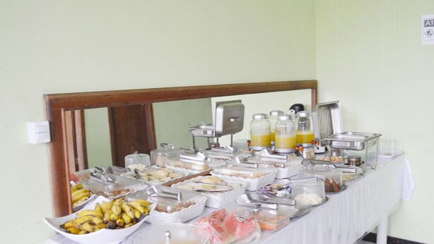 Un tavolo da buffet con diversi cibi e bevande, tra cui frutta, cereali e succhi di frutta.