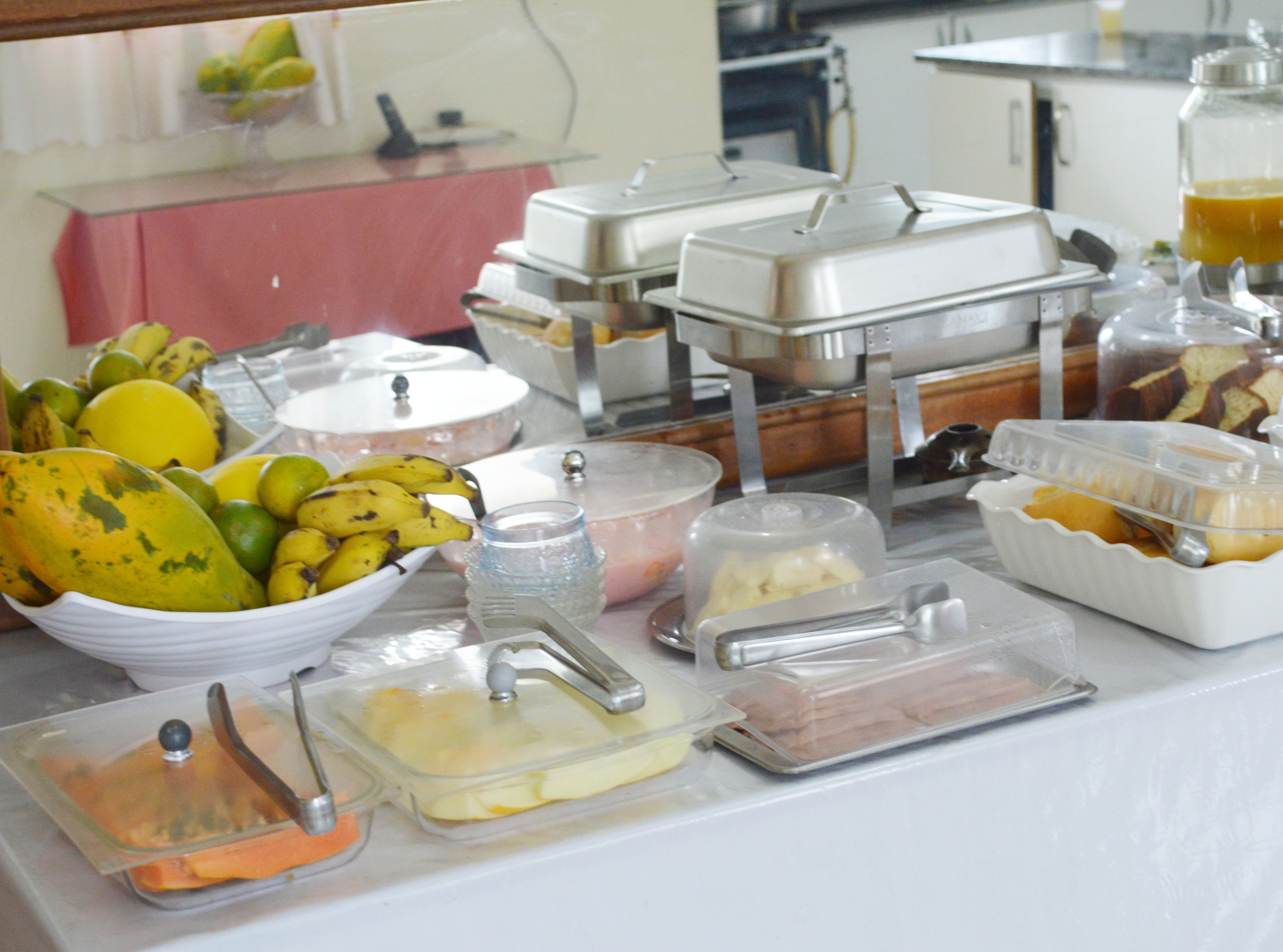 Uma mesa de buffet com diversos alimentos e recipientes.