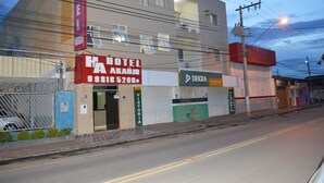 Un albergo con un cartello rosso, una porta chiusa con persiana e un ingresso ben visibile.