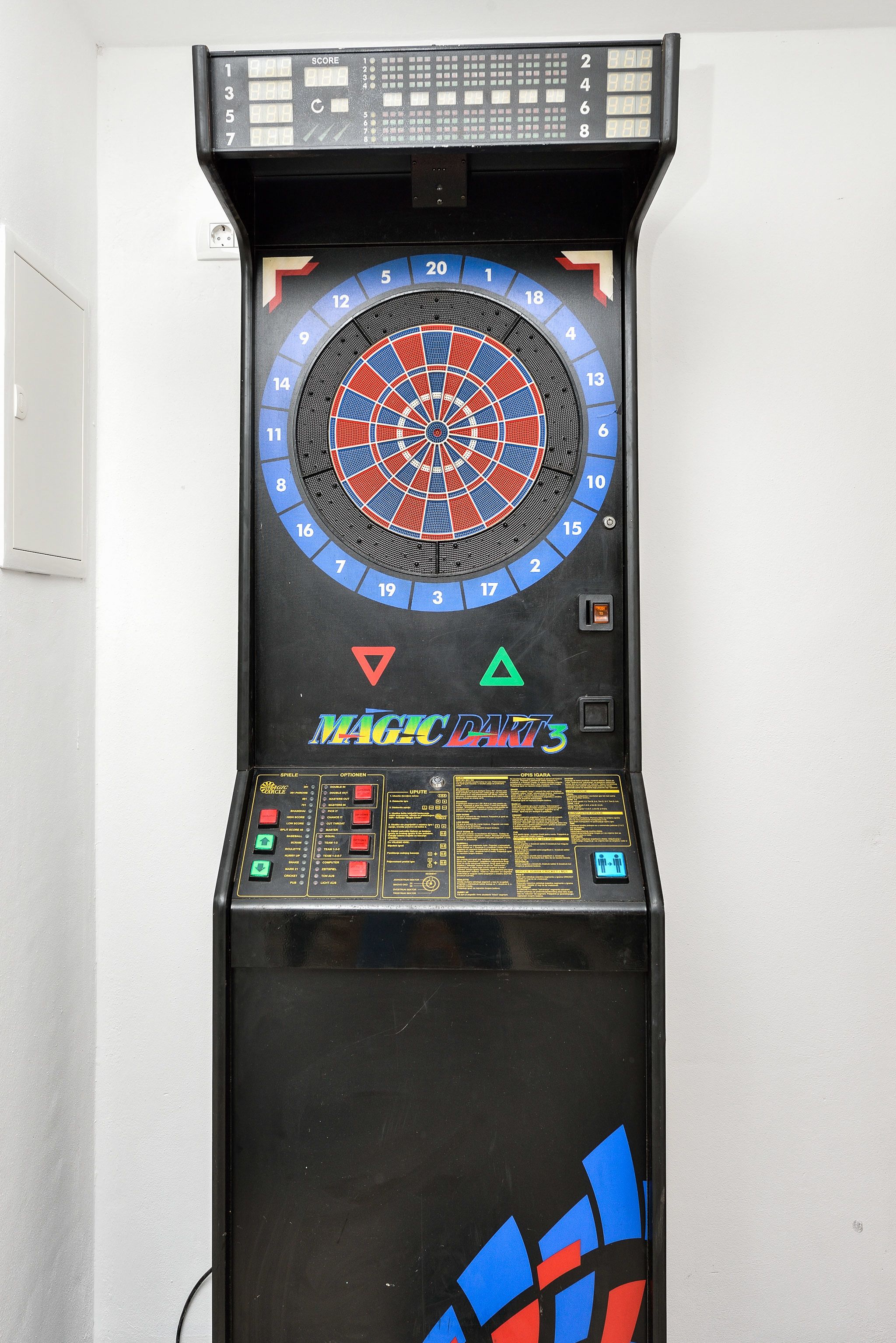 A dartboard with a score display and a control panel.