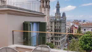 Un balcón con vistas a edificios históricos, una mesa y dos sillas.