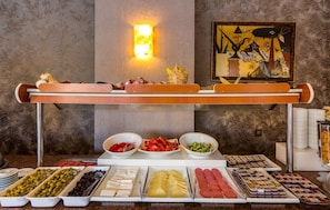Ein reichhaltiges Buffet mit verschiedenen Speisen und einem Gemälde an der Wand.