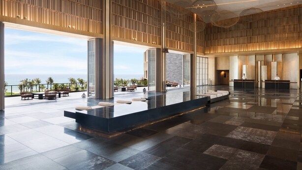 A spacious lobby with a reception desk, seating area, and a view of the ocean. - Marriott Resort Xiangshui Bay (Lingshui)