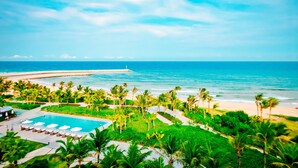 A resort with a pool, palm trees, and a beach view. - Marriott Resort Xiangshui Bay (Lingshui)