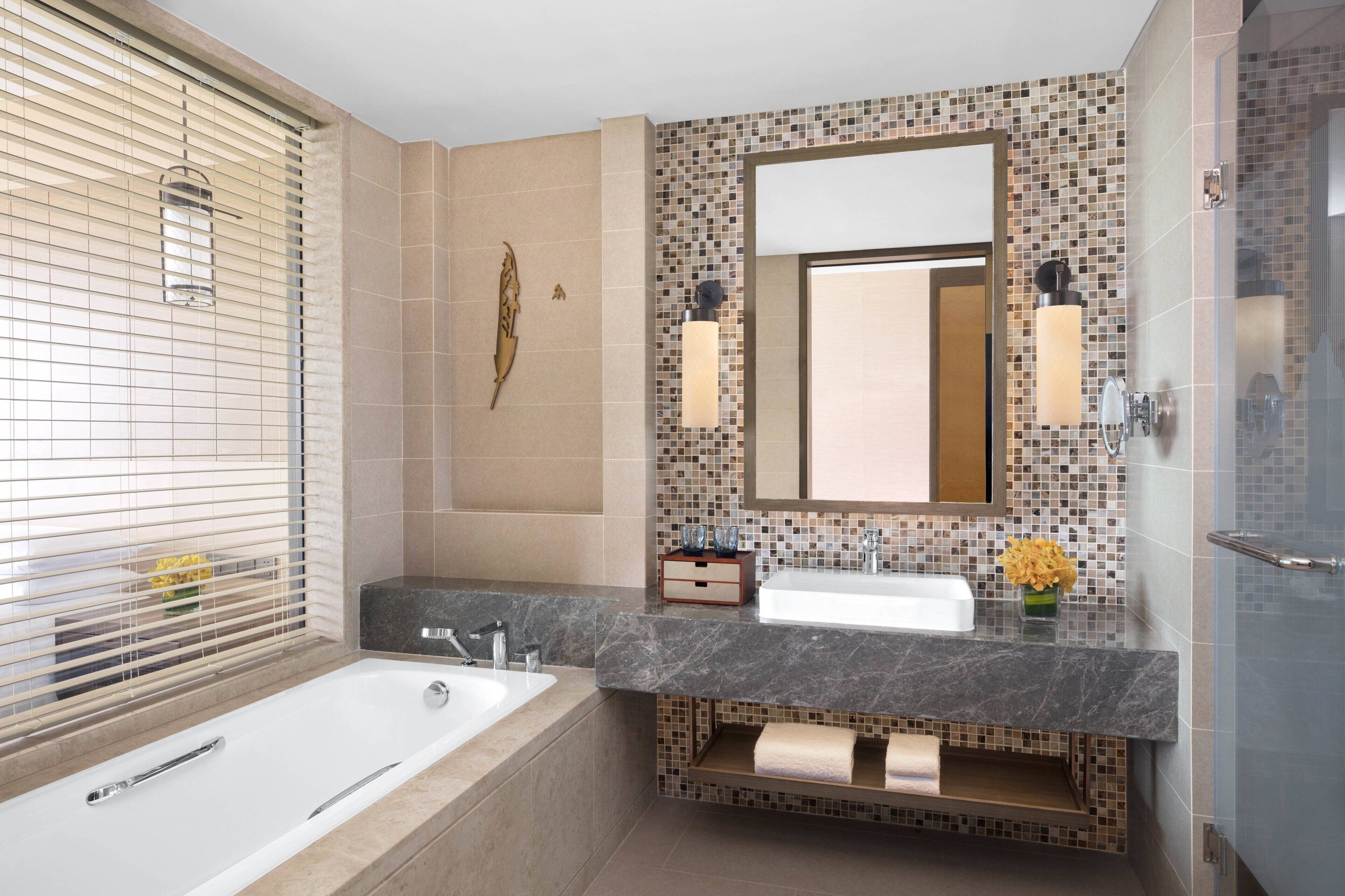 Une salle de bain moderne avec une baignoire, un lavabo et un meuble-lavabo.