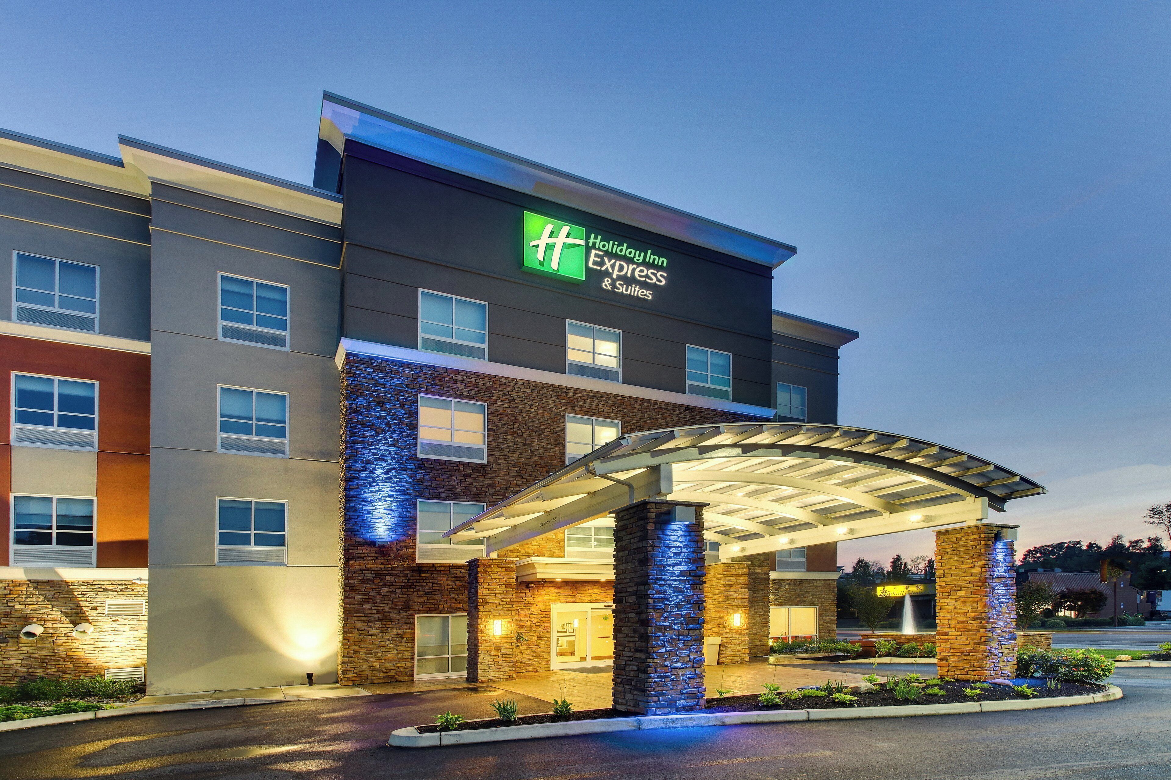 A Holiday Inn Express & Suites building with a covered entrance and a stone facade.