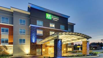 A Holiday Inn Express & Suites building with a covered entrance and a stone facade.