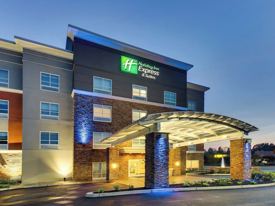 A Holiday Inn Express & Suites building with a covered entrance and a stone facade.