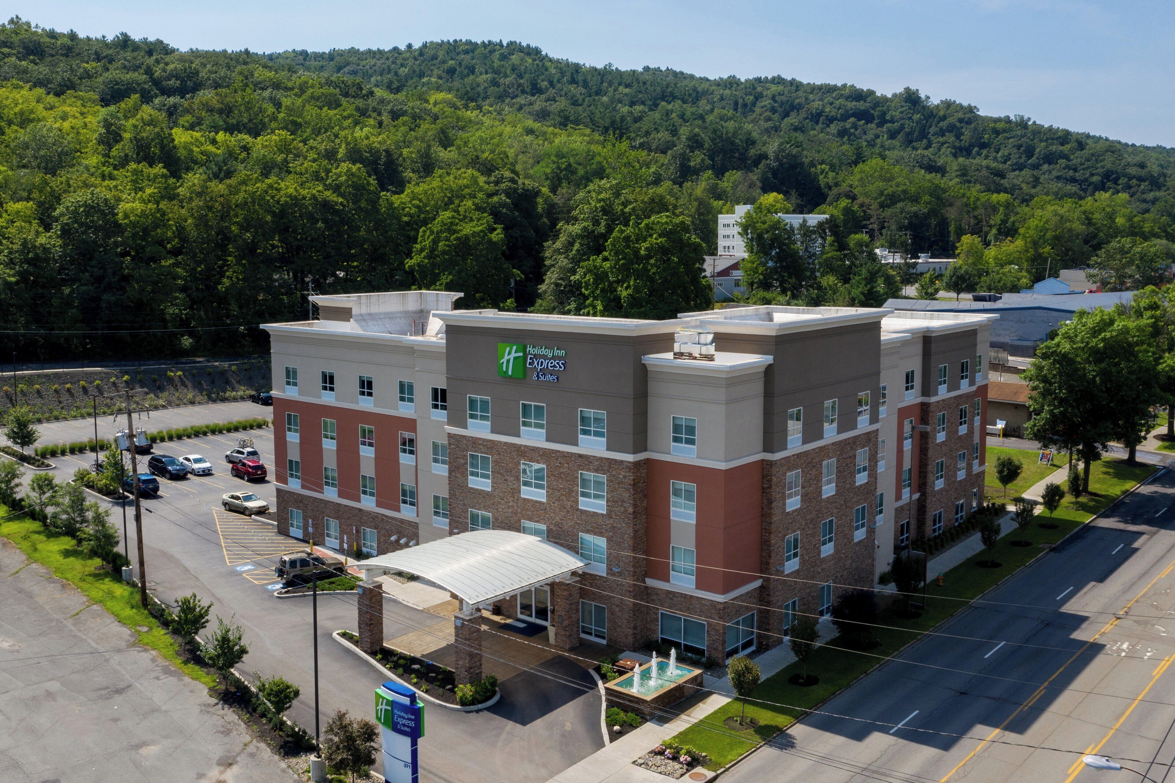 Un bâtiment de l’hôtel Holiday Inn Express avec un parking et une fontaine.