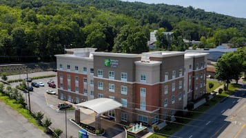 A Holiday Inn Express building with a parking lot and a fountain.