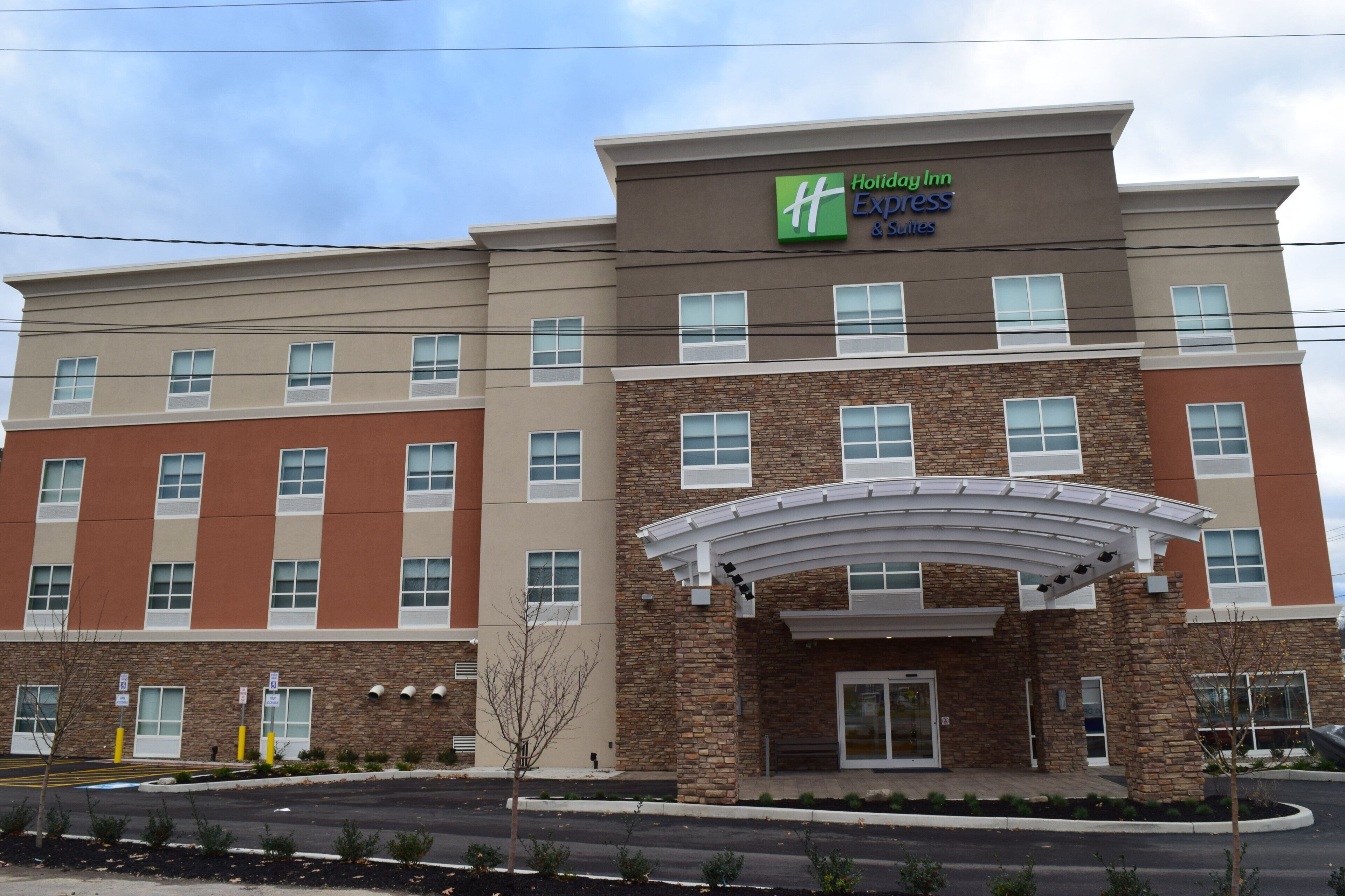 A Holiday Inn Express hotel with a modern facade, multiple windows, and a covered entrance.