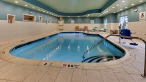 An indoor swimming pool with clear depth markers, a pool lift, and a seating area with chairs. - Holiday Inn Express & Suites Ithaca by IHG (Ithaca)
