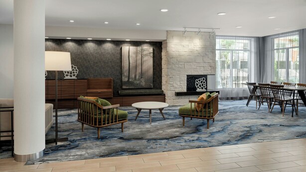 A modern living room with a stone fireplace, a large abstract painting, and a dining area with a table and chairs.