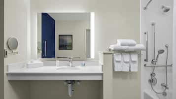 A modern bathroom with a white sink, mirror, and shower.