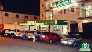 A hotel with multiple floors, a visible reception area, and several parked cars in front. - Hotel e Restaurante Residencial (Montes Claros)