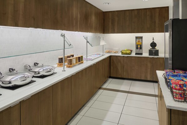 A modern kitchen with wooden cabinets, a white countertop, and a refrigerator.