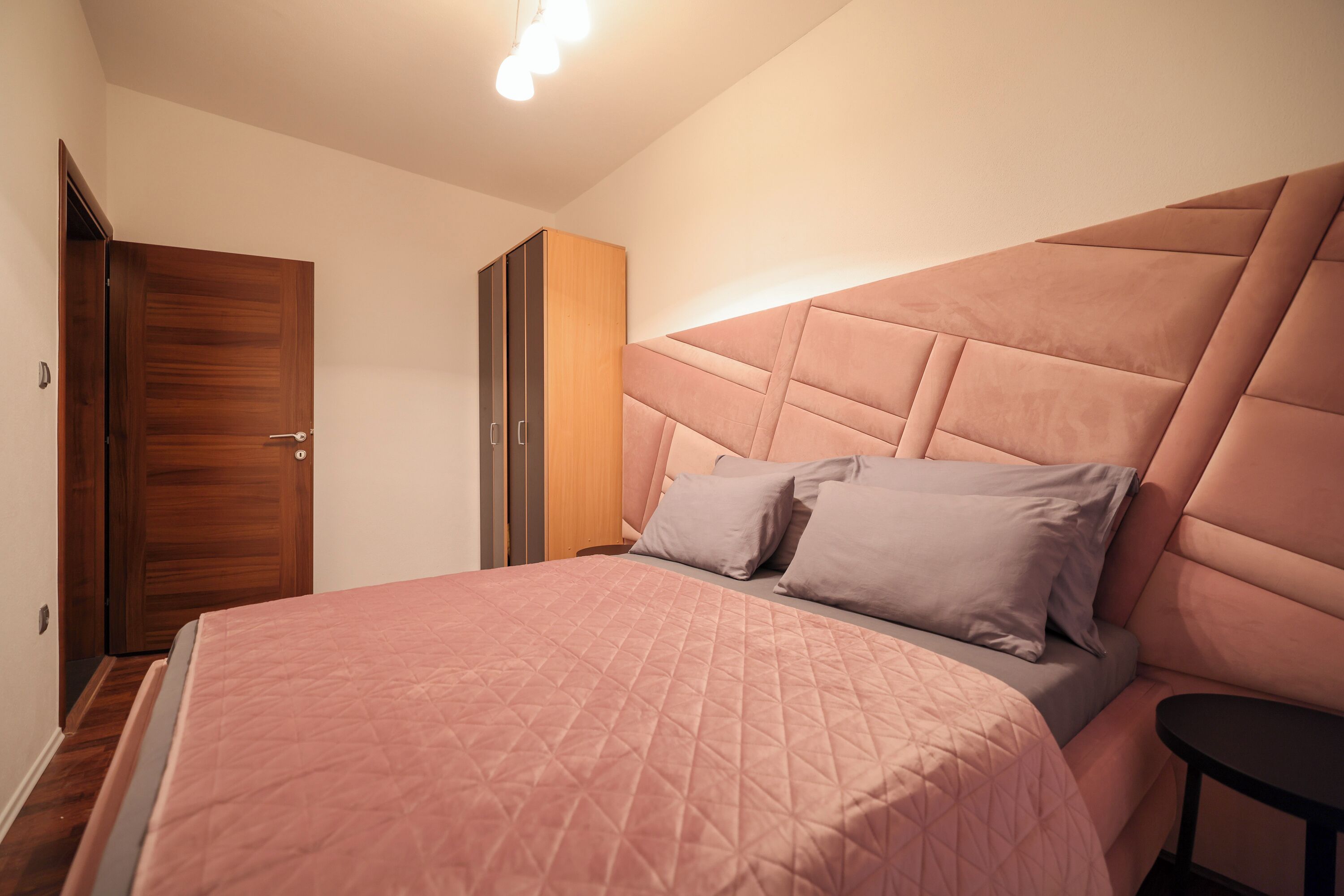 Une chambre à coucher avec un grand lit, une armoire et une table de chevet.