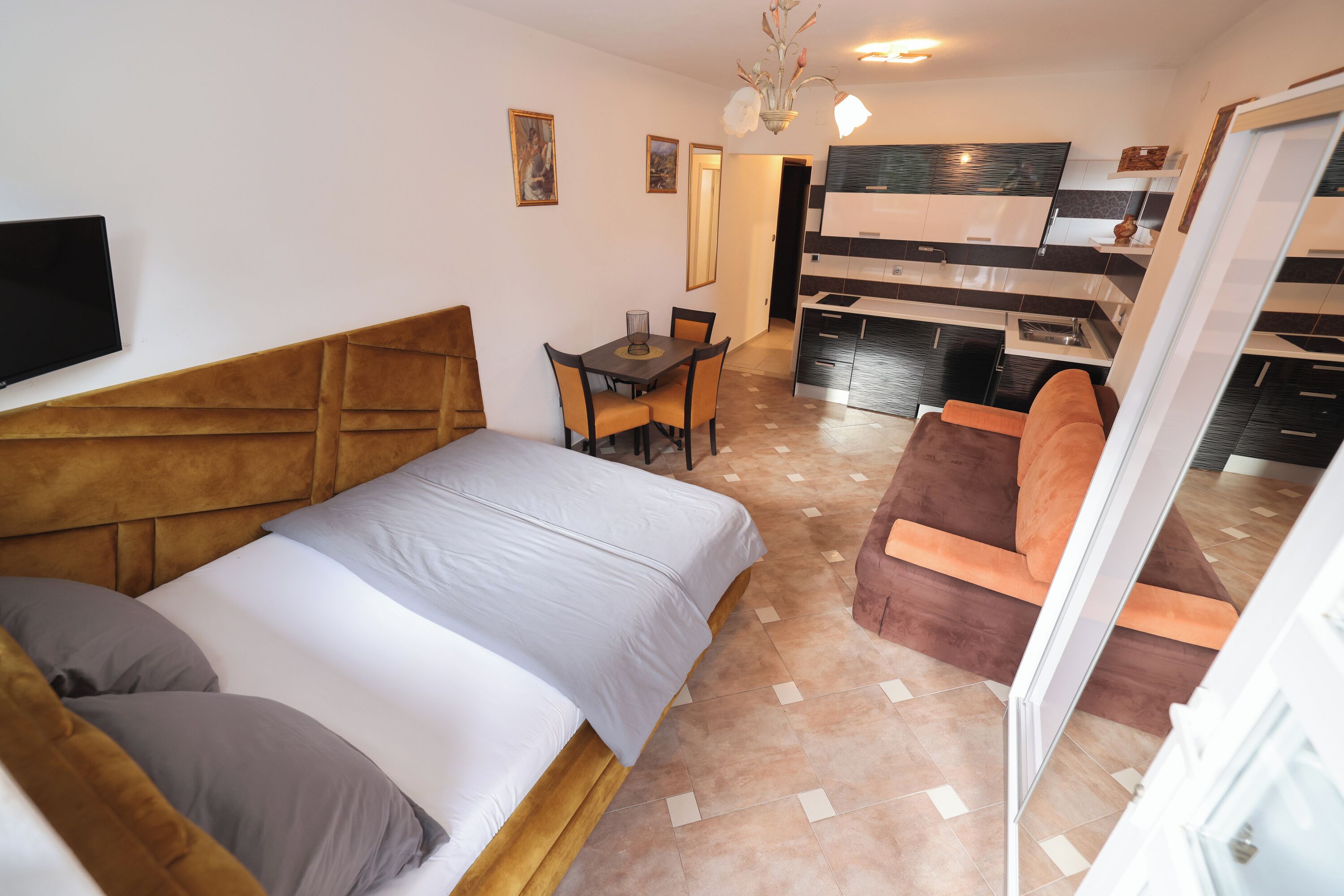Een hotelkamer met een bed, een bureau, een stoel en een kitchenette.