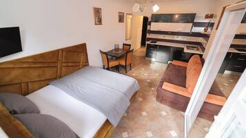 Een hotelkamer met een bed, een bureau, een stoel en een kitchenette.