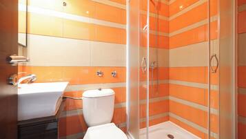 A bathroom with a glass-enclosed shower, a white sink, and a toilet.