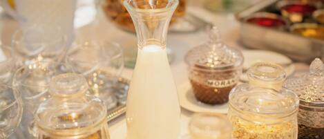 Una mesa con diversos alimentos y recipientes, incluyendo una jarra de leche y frascos con diferentes contenidos.
