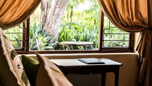A room with a window, a small table, and a chair.