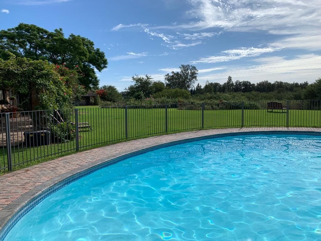 Una piscina al aire libre, sillones reclinables de piscina