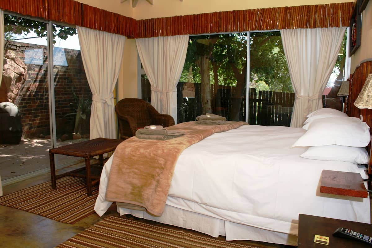 A bedroom with a large bed, a chair, and a small table.