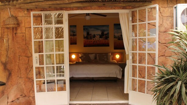 Une chambre avec un lit, deux lampes de chevet et un tableau au mur.