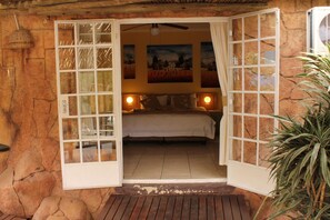 Quarto com uma cama, duas luminárias de cabeceira e um quadro na parede.