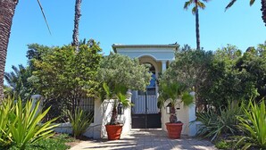 A gated entrance with a white building and a clear blue sky. - Atlantic Breeze (Cape Town)