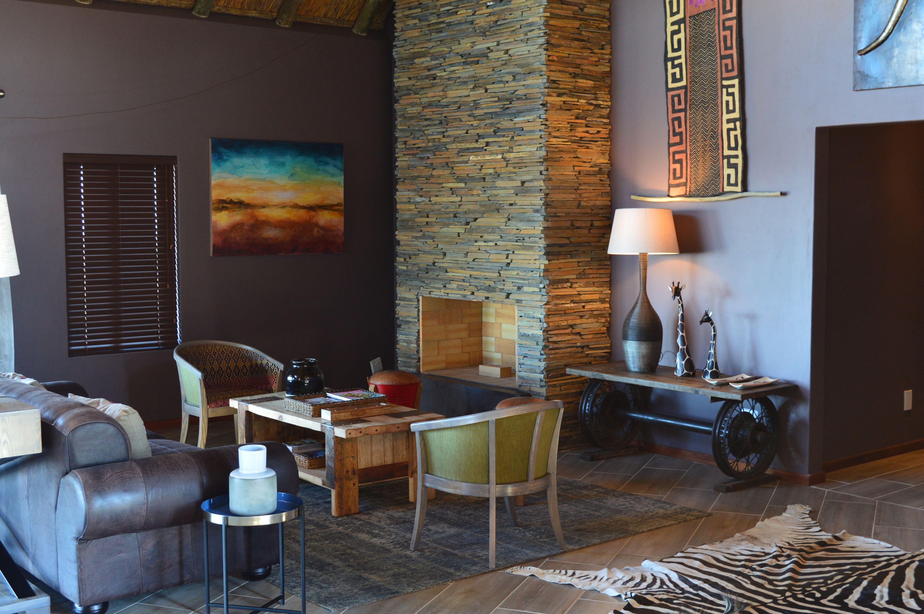 A cozy living room with a stone accent wall, a comfortable sofa, a wooden coffee table, and a zebra rug.