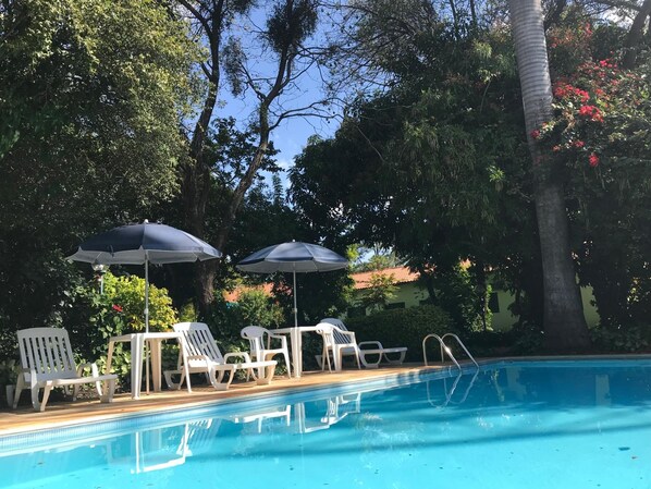 Alberca al aire libre y camastros 