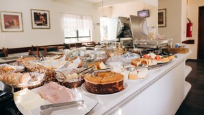 A buffet with various food items including cakes, pastries, and meats. - Hotel Passaledo (Indaiatuba)