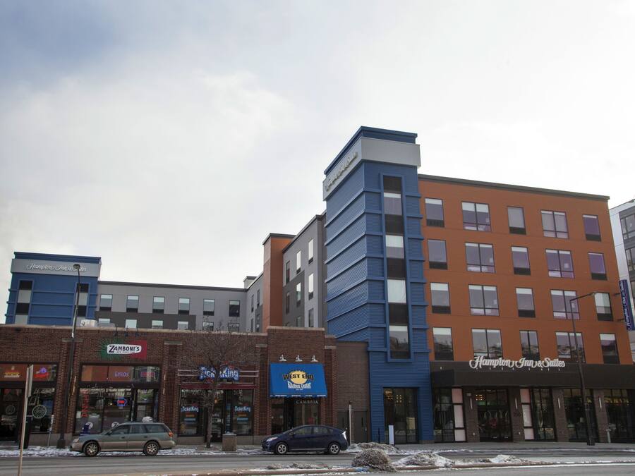 En bygning med flere etager og forskellige butikker, heriblandt en Zamboni-service og et hotel kaldet Hampton Inn & Suites.