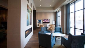 A modern lobby with a seating area, large windows, and artwork on the walls. - Hampton Inn & Suites Downtown St. Paul (St. Paul)