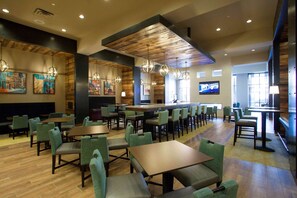 A spacious restaurant with high ceilings, wooden beams, and a variety of seating options including tables and booths.