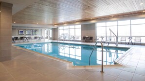 An indoor swimming pool with clear water, surrounded by tiled flooring and a wooden ceiling. - Hampton Inn & Suites Downtown St. Paul (St. Paul)