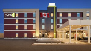 Een modern hotel met een opvallende Canadese vlag, meerdere verdiepingen en een overdekte entree.