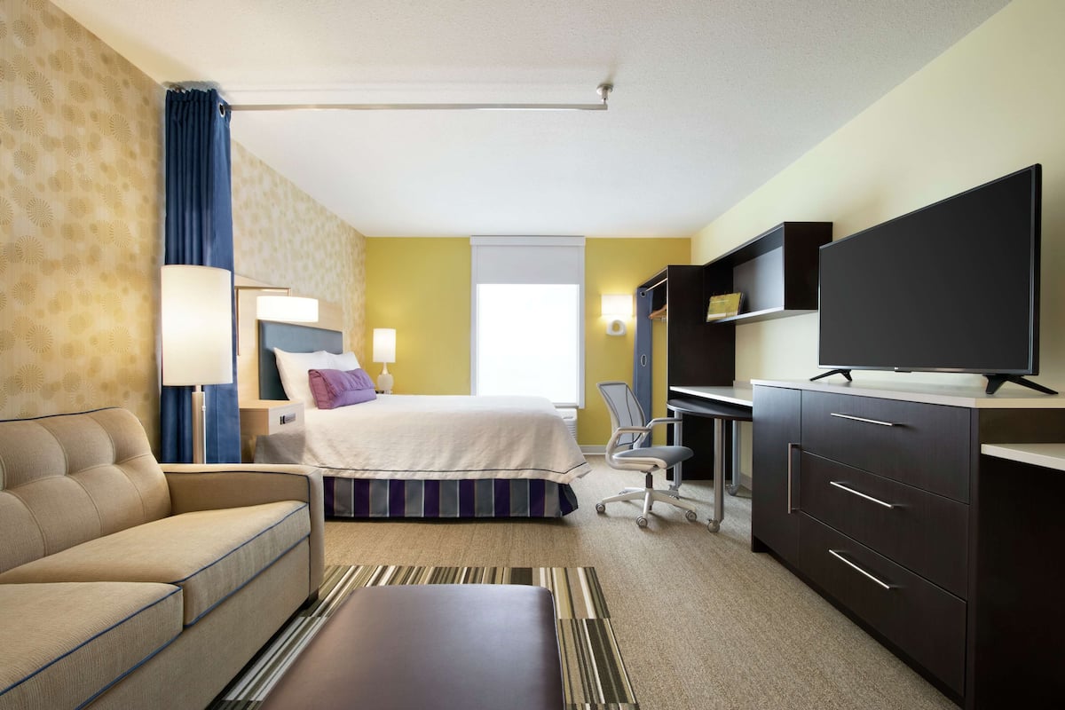Premium bedding, desk, laptop workspace, blackout drapes