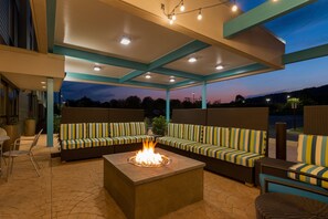 An outdoor seating area with a fire feature, covered by a roof, and a view of the sky. - Home2 Suites by Hilton Downingtown Exton Route 30 (Downingtown)
