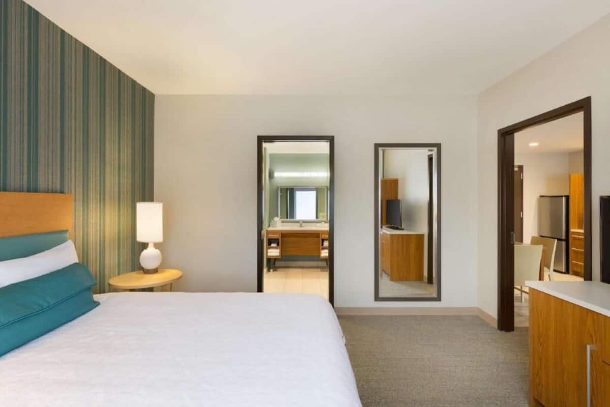 Escritorio, cortinas blackout y tabla de planchar con plancha