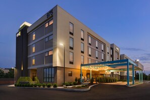 A modern hotel building with a covered entrance and a well-lit facade. - Home2 Suites by Hilton Downingtown Exton Route 30 (Downingtown)