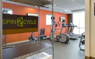 Un gimnasio con un letrero que dice "SPIN2 CYCLE" y equipo de ejercicio.